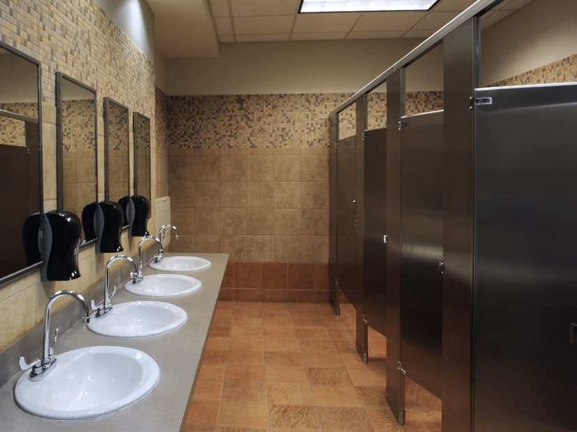Modern commercial bathroom with multiple stalls and accessibility features