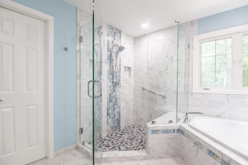 Modern shower remodel with rainfall head, body sprays, and natural stone tile